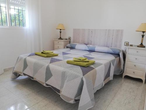 1 dormitorio con 1 cama y 2 toallas verdes en Chalet Costa de la Luz - La Barrosa, en Chiclana de la Frontera