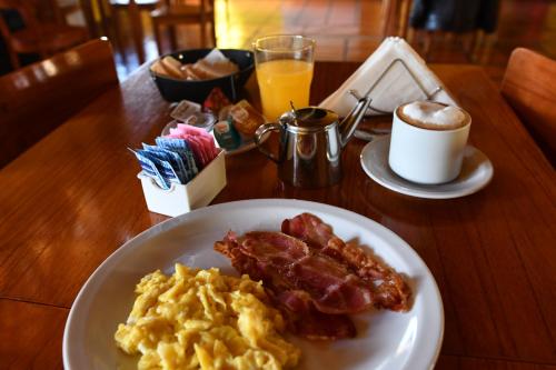 a white plate topped with breakfast foods and a cup of coffee at Rancho Grande in El Chalten