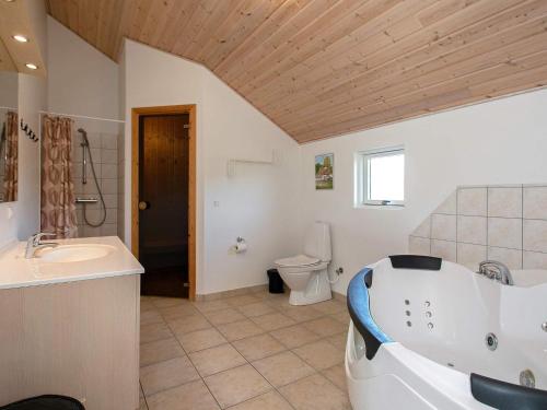 a bathroom with a tub and a sink and a toilet at 12 person holiday home in Idestrup in Marielyst