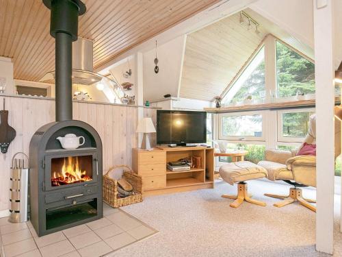 a living room with a fireplace in a house at 6 person holiday home in Gedsted in Gedsted