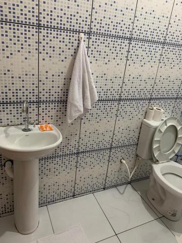 a bathroom with a toilet and a sink at FAMÍLIA CHARLEAUX in Aparecida