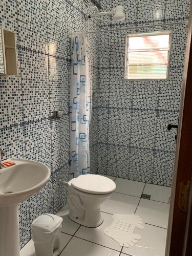 a bathroom with a toilet and a sink at FAMÍLIA CHARLEAUX in Aparecida