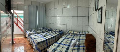 a room with three beds in a room at FAMÍLIA CHARLEAUX in Aparecida