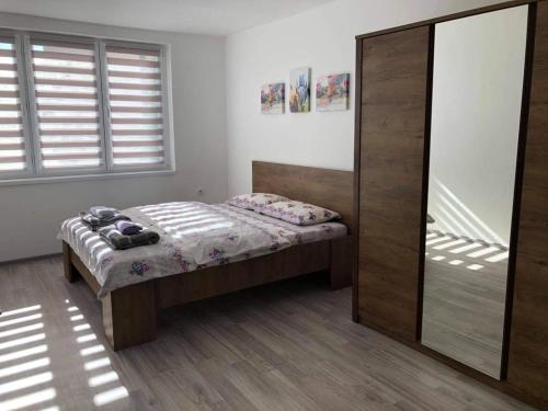 a bedroom with a bed and a sliding glass door at Apartman MONA Bijeljina in Bijeljina