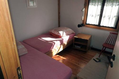 mały pokój z 2 łóżkami i stołem w obiekcie Modrzewiowy domek letniskowy - Stare Czaple w mieście Brodnica