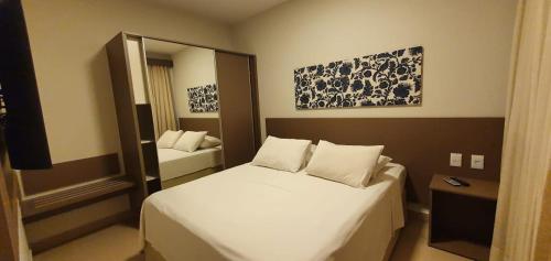 a small bedroom with a bed and a mirror at PARK VEREDAS FLAT 322 in Rio Quente