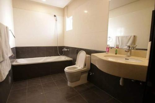 a bathroom with a sink and a toilet and a bath tub at Hira Guest House in Karachi