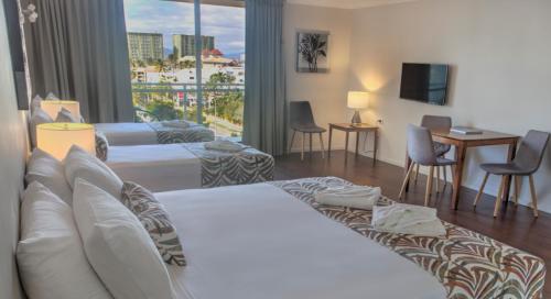 a hotel room with a bed and a large window at Cairns Plaza Hotel in Cairns
