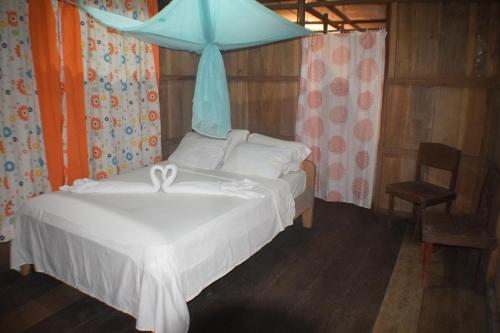 a bedroom with a bed with a blue canopy at Lodge Jungle Wolf Expeditions in Yucuruche