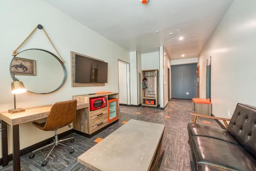 a living room with a desk and a mirror at Hotel Lexen Newhall & Santa Clarita - Near Six Flags Magic Mountain in Santa Clarita