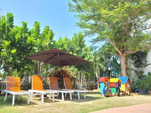 a group of tables and chairs with an umbrella at 地中海海景包棟-無邊際泳池 家庭出遊 朋友聚會 生態體驗 推薦包棟首選 in Xiaoliuqiu