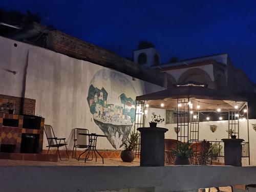 a mural on the side of a building at night at La Casa del Abuelo in San Miguel de Allende