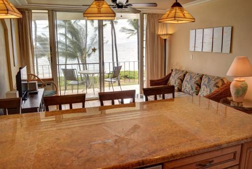 a kitchen and living room with a large marble counter top at Hale Kai O'Kihei 302 in Kihei