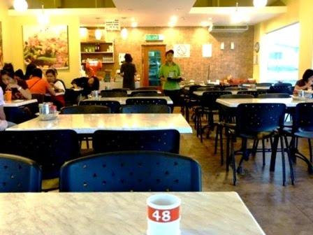 a restaurant with tables and chairs and people sitting at tables at PINTARMAN SUITES @ MIRI TIMES SQUARE in Miri