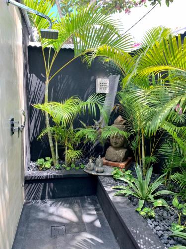 a garden with palm trees and plants in a courtyard at Hari Indah Boutique Hotel & Spa in Uluwatu