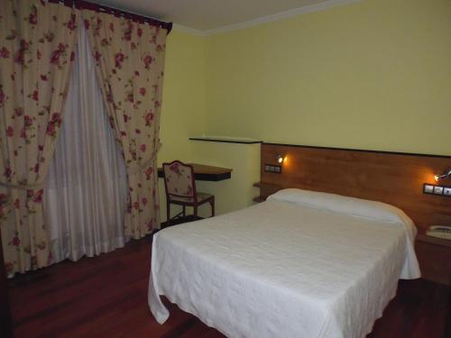 a hotel room with a bed and a table at Cruceiro do Monte in Tui