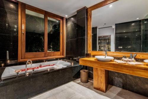 a bathroom with a tub and a sink at Villa De Jiwa 495 Seminyak in Seminyak