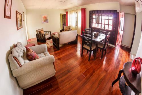 a living room with a table and a dining room at Delcafetalcr in San José