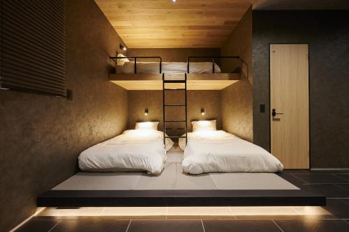 two beds in a room with two bunk beds at Colors Hakata in Fukuoka