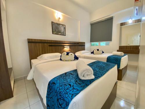 a hotel room with two beds with towels on them at Century Suria Aparment Langkawi by Zervin in Kuah