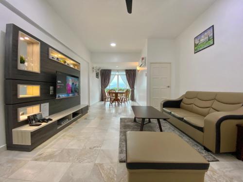 a living room with a couch and a tv at Century Suria Aparment Langkawi by Zervin in Kuah