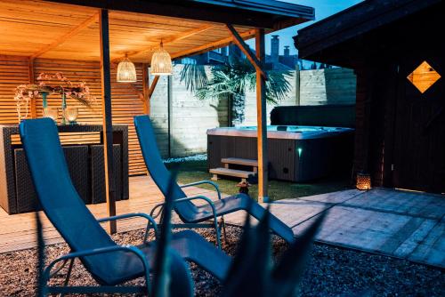 a patio with blue chairs and a hot tub at B&B A Dream City spa & Massages in Bruges