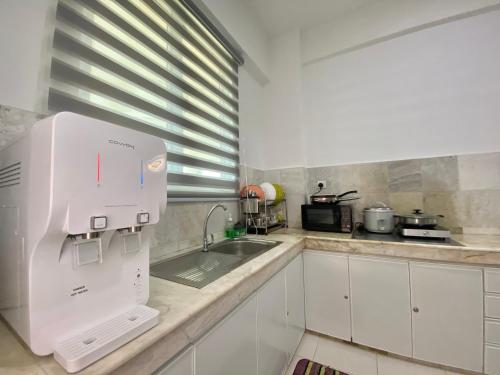 a kitchen with a sink and a white appliance at Century Suria Aparment Langkawi by Zervin in Kuah
