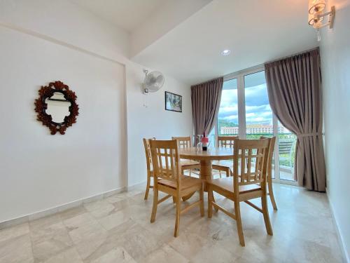 a dining room with a table and chairs and a window at Century Suria Aparment Langkawi by Zervin in Kuah
