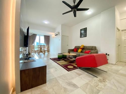a living room with a couch and a red chair at Century Suria Aparment Langkawi by Zervin in Kuah