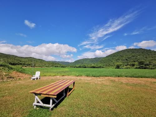 a picnic table and a chair in a field at 樂逃園 Leto Retreat 屏東滿州包棟民宿 in Manzhou