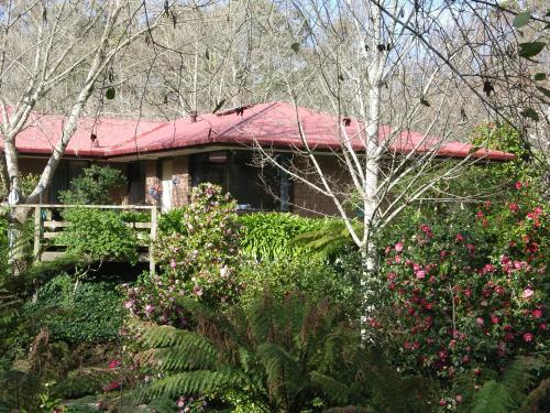 a house with a red roof and some flowers at Adelaide Hills B&B Accommodation in Stirling