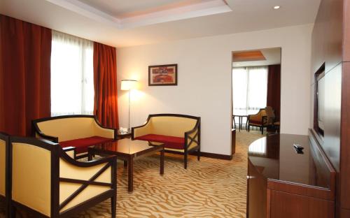 a hotel room with a living area with a tv and chairs at Holiday Inn Olaya by IHG in Riyadh