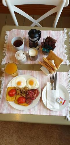 a table with a breakfast of eggs and toast at Homestay On Queen in Westport