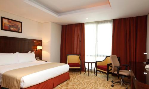 a hotel room with a bed and a desk at Holiday Inn Olaya by IHG in Riyadh
