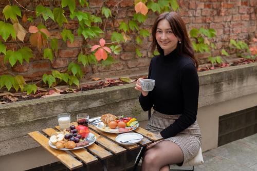 a woman sitting on a bench with a plate of food at Miss Sophie's New Town & Wellness in Prague