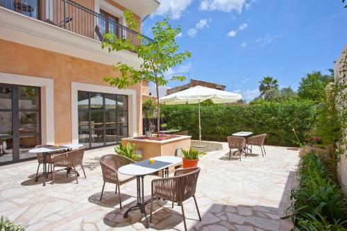 d'une terrasse avec des tables, des chaises et un parasol. dans l'établissement Boutique Hotel Petit Sant Miquel, à Calonge