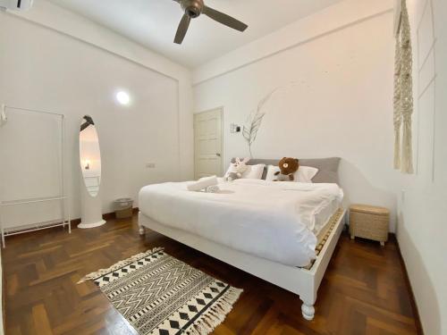 a white bedroom with a bed with a teddy bear on it at Century Suria Aparment Langkawi by Zervin in Kuah