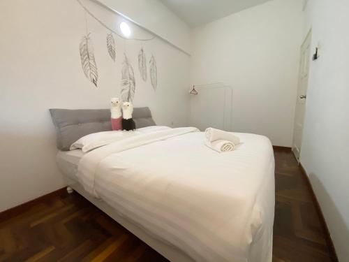 a bedroom with a white bed with two cats on it at Century Suria Aparment Langkawi by Zervin in Kuah