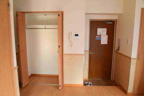 una puerta abierta en un pasillo con un perro sentado al lado en 上野之家分館家庭房, en Tokio