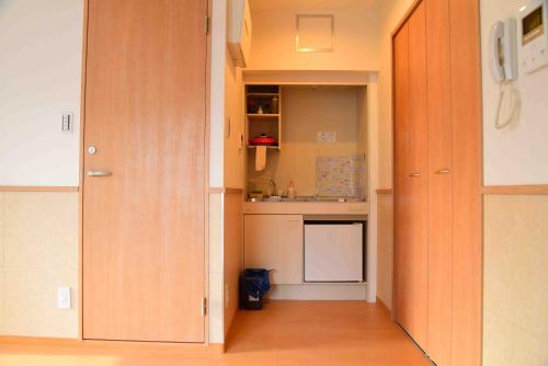 a kitchen with wooden cabinets and a kitchen with a sink at 上野之家分館家庭房 in Tokyo