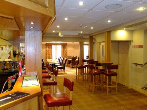 a restaurant with a bar and tables and chairs at The Golden Lion Hotel in Maryport