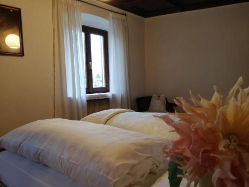 1 dormitorio con 2 camas y ventana en Ansitz Grustdorf, en Appiano sulla Strada del Vino