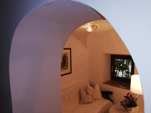 an archway in a room with a couch and a window at Ansitz Grustdorf in Appiano sulla Strada del Vino