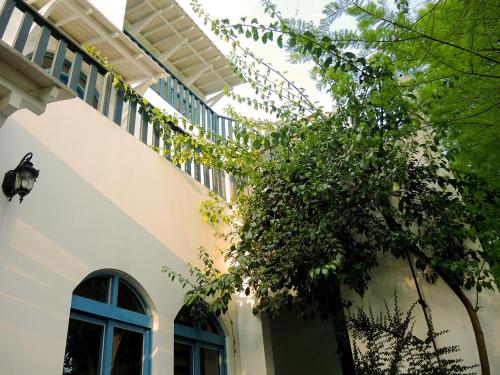 a white building with a tree in front of it at 慎重開華莊園民宿 in Puli