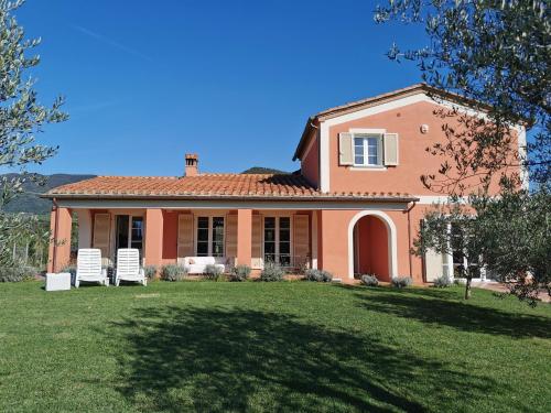 a house with two lawn chairs in the yard at B&B Luna Nuova in Sarzana