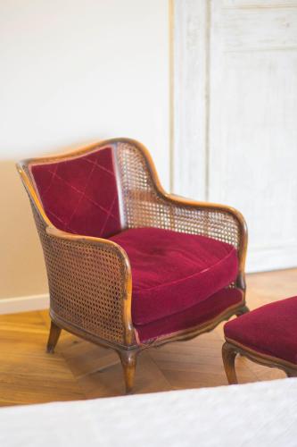 a wicker chair with a red cushion sitting in a room at B&B Attico Taranto in Caltagirone