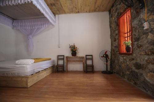 a bedroom with a bed and a table and a window at Yen Nhi Homestay Ban Gioc in Cao Bằng