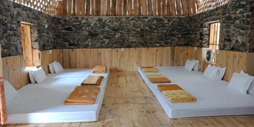 a room with four beds in a room with rocks at Yen Nhi Homestay Ban Gioc in Cao Bằng