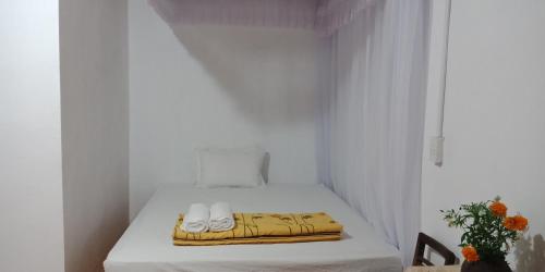 a small room with a bed with white curtains at Yen Nhi Homestay Ban Gioc in Cao Bằng