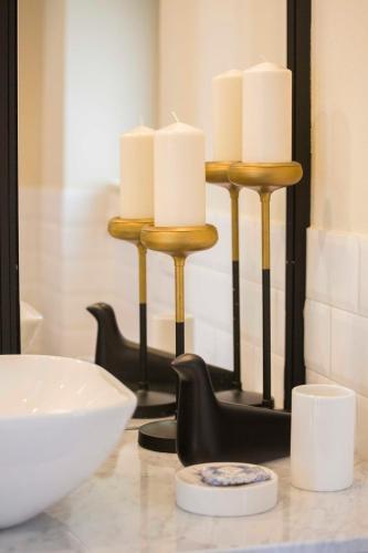 a candle holder with white candles on a table at B&B Attico Taranto in Caltagirone